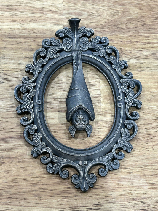 Hanging bat in baroque frame